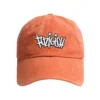 Enzyme-washed orange Fuzigish dad cap with white and black embroidered logo on the front - Front view